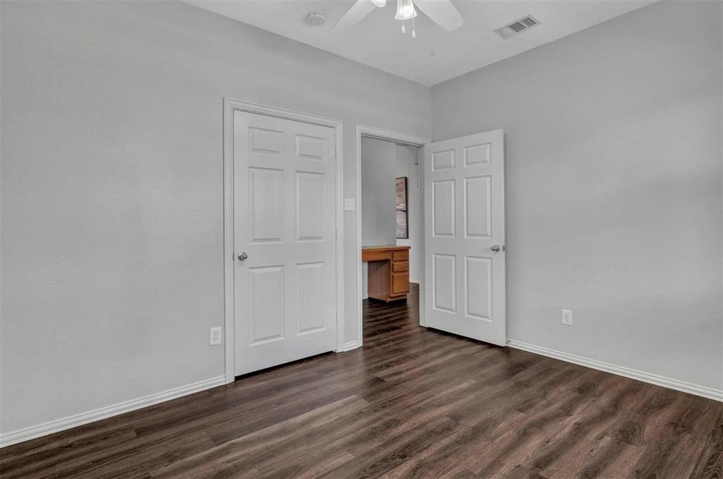 Wood-finish flooring with light gray walls, white trim, and a ceiling fan