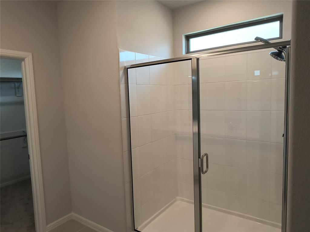 Shower enclosure with white tile surround and a transom window