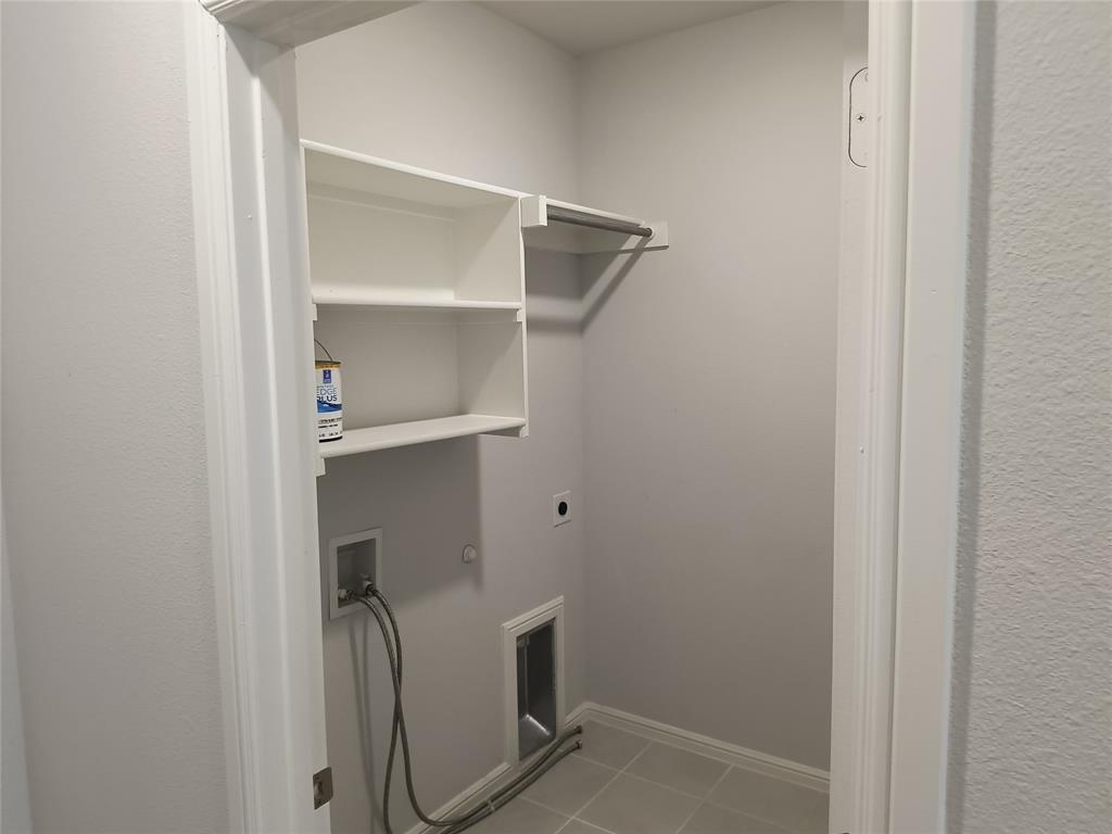 White built-in shelving, metal hanging rod, and light gray tiled flooring