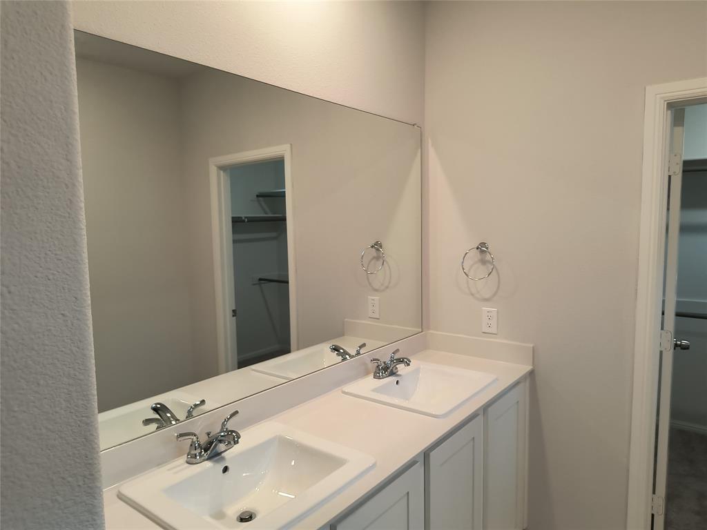 Double vanity with integrated sinks, white countertops, and chrome faucets