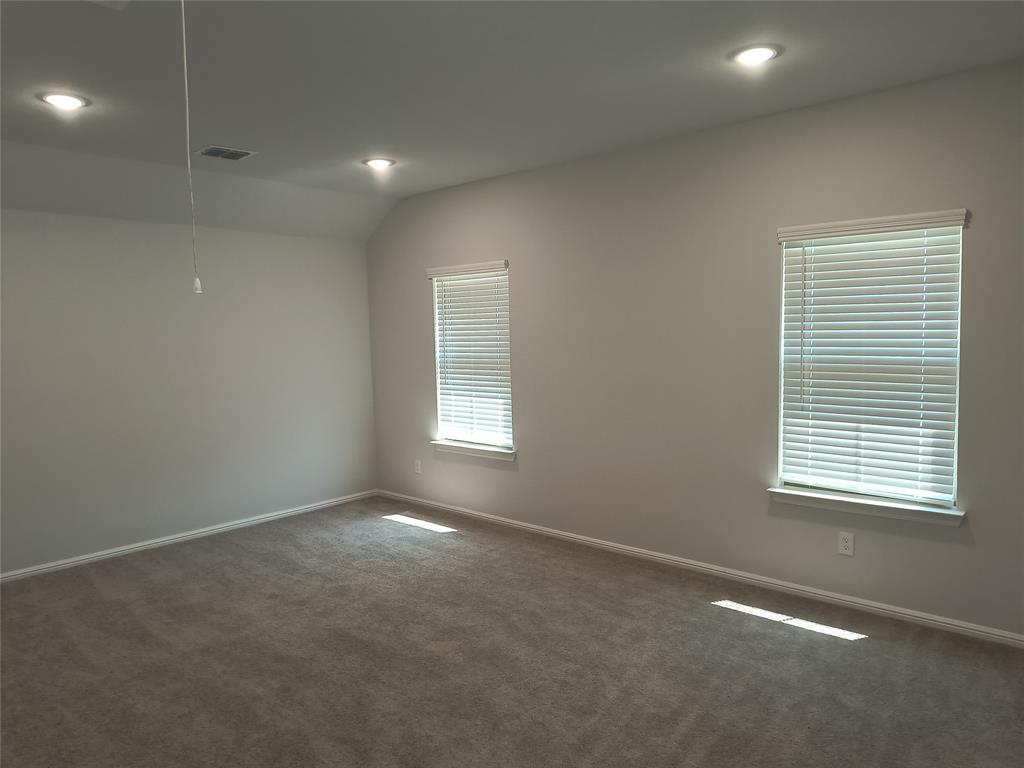 Recessed lighting, sloped ceiling, two windows with blinds, and carpet flooring