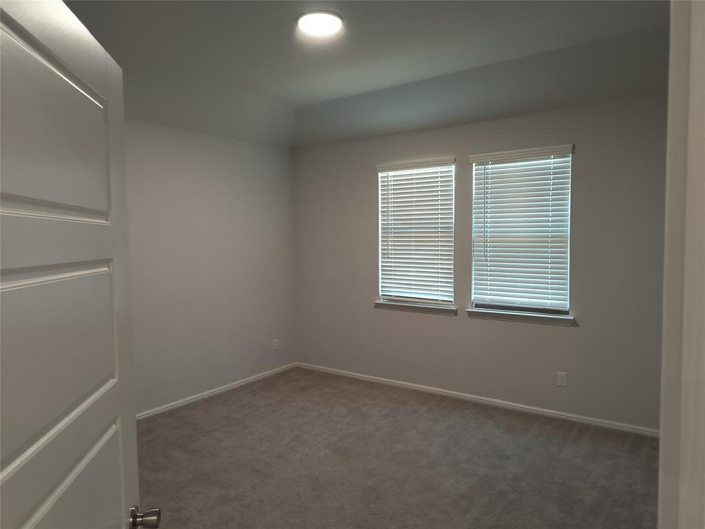 Recessed ceiling lighting, two windows with blinds, light gray wall paint, and gray carpeting