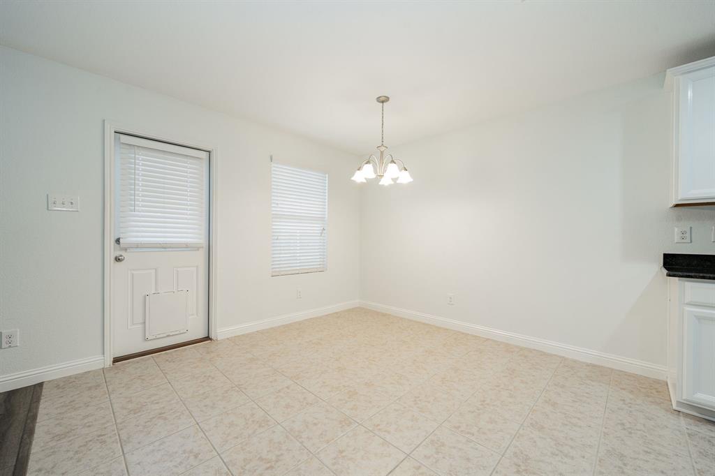 Unfurnished dining area with a chandelier and light tile patterned flooring