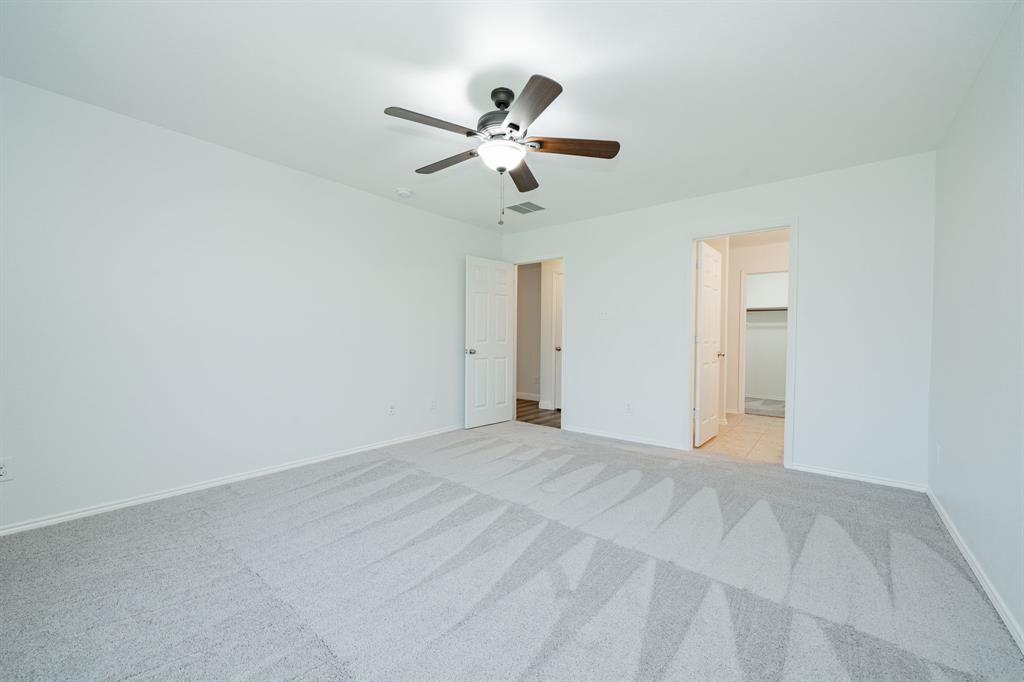 Unfurnished bedroom with light colored carpet and ceiling fan