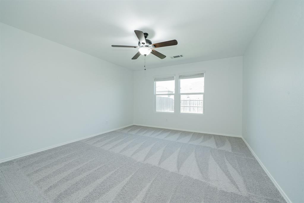 Spare room featuring light colored carpet and ceiling fan