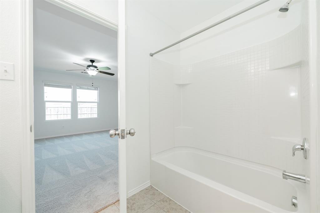 Full bath with bathing tub / shower combination, a ceiling fan, and tile patterned flooring