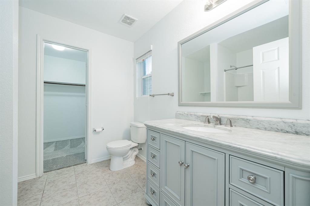 Bathroom featuring vanity, a spacious closet, and tile patterned flooring