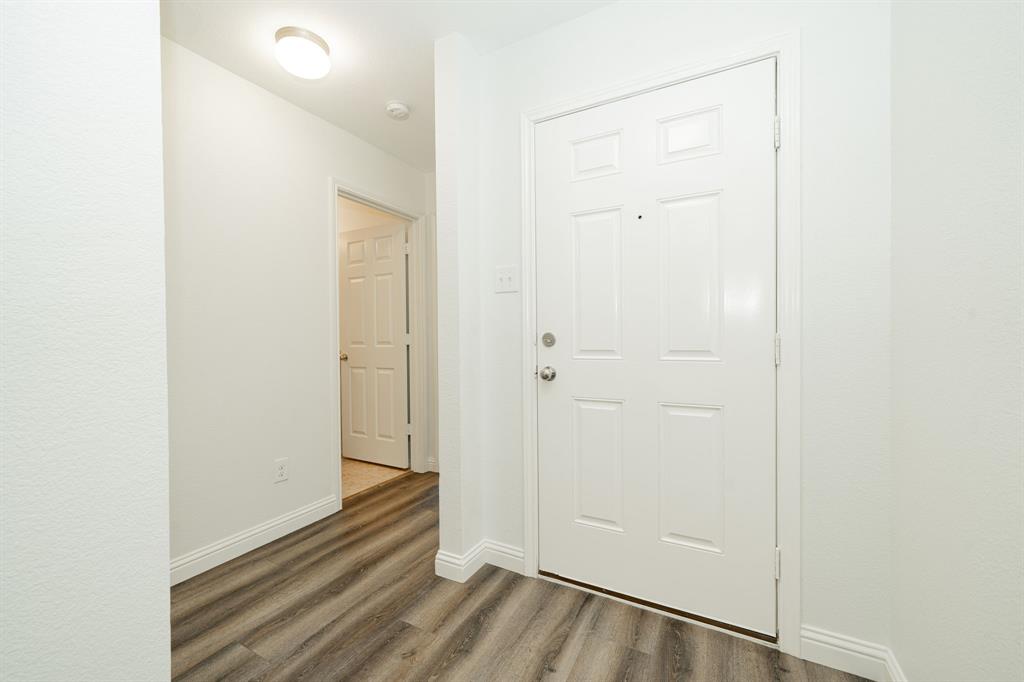 Entryway with wood finished floors and baseboards