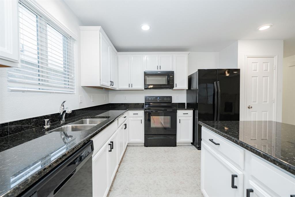 Kitchen featuring black appliances, white cabinets, dark stone countertops, recessed lighting, and light tile patterned flooring