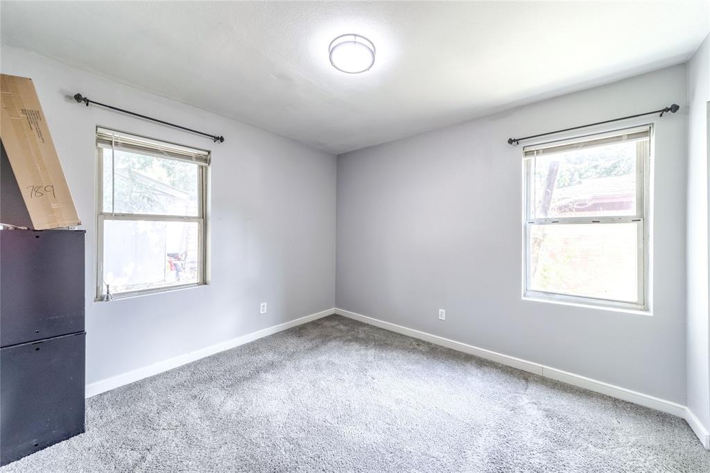 Carpeted spare room featuring baseboards