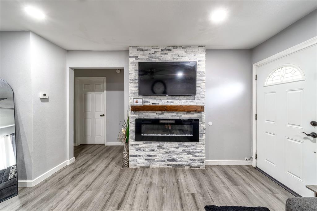 Unfurnished living room featuring a large fireplace and wood finished floors