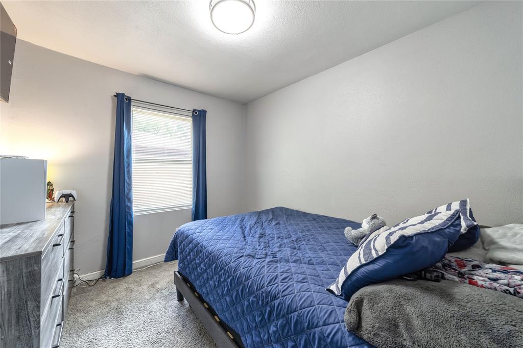 Bedroom with light colored carpet and baseboards