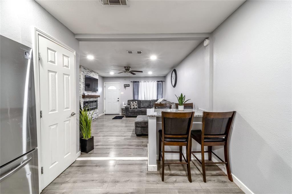 Dining space with wood finished floors, recessed lighting, a large fireplace, and a textured wall