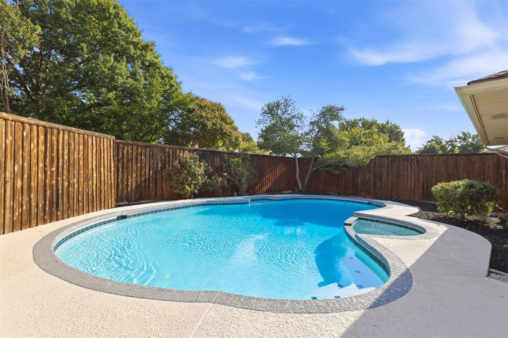 In-ground swimming pool with integrated spa and concrete decking