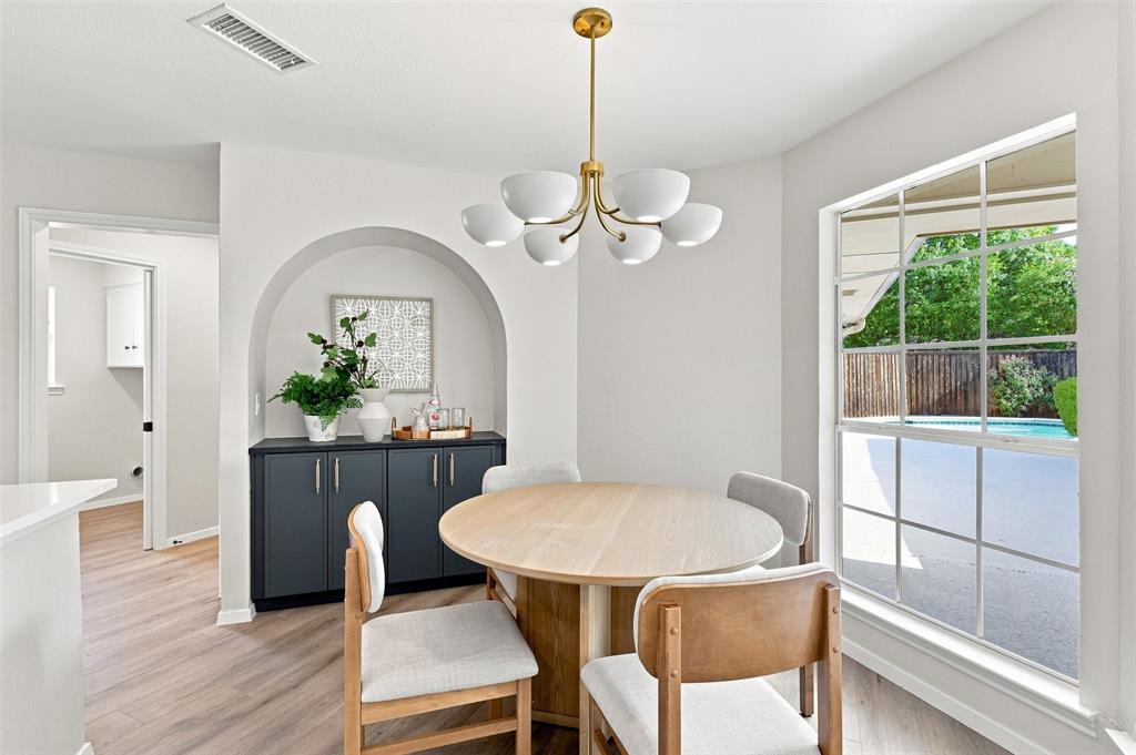 Arched built-in cabinetry with a countertop, wood-finish flooring, and a multi-bulb chandelier