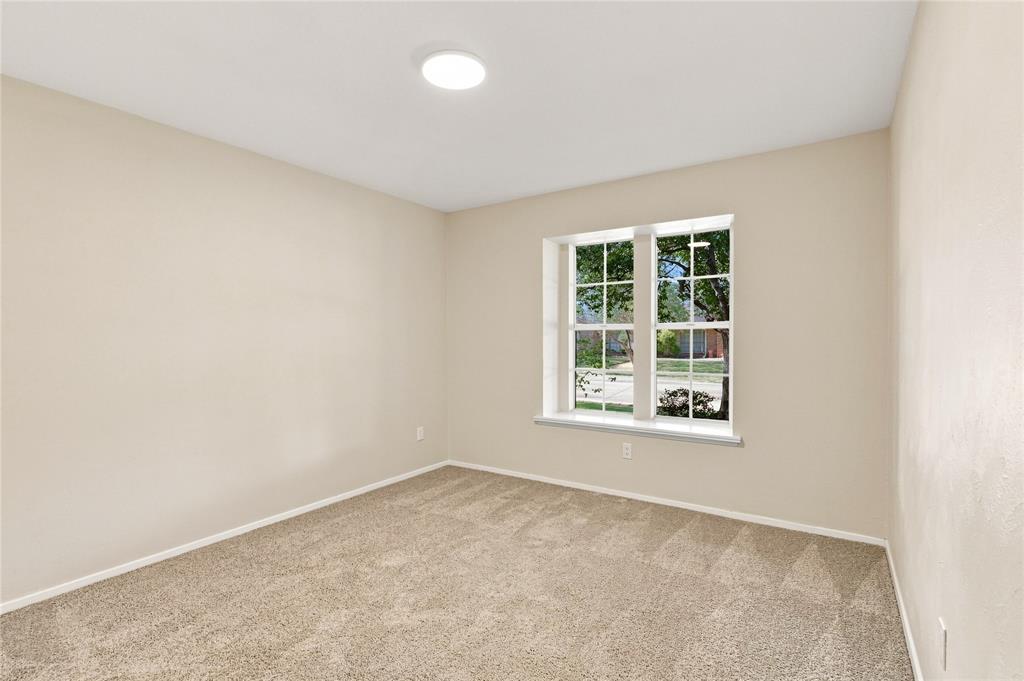 Neutral-toned carpeting, light-colored wall paint, and a window with white trim
