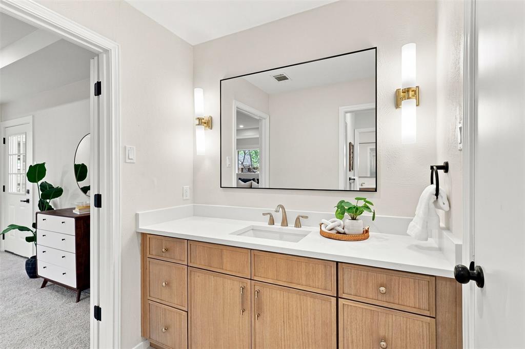 Wood-finish vanity with a white countertop and undermount sink