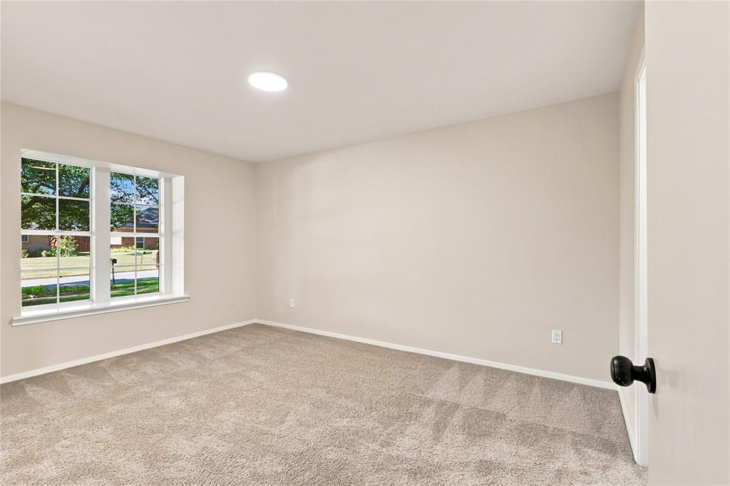 Neutral-toned wall paint, recessed ceiling lighting, light-colored carpeting, white window trim, and a black doorknob