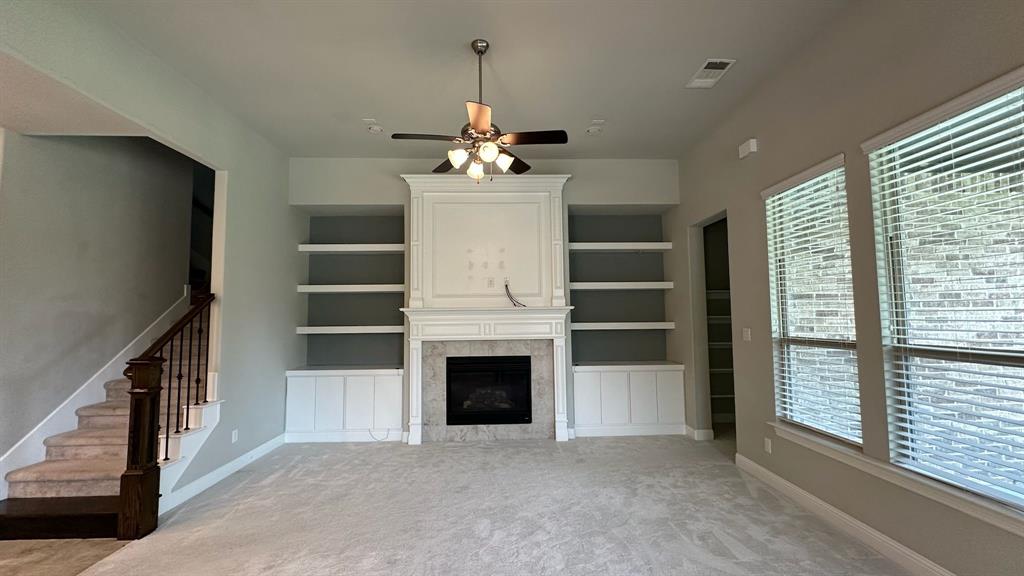Spacious kitchen featuring white cabinetry, a large center island with a granite countertop, a tile backsplash, and stainless steel built-in appliances