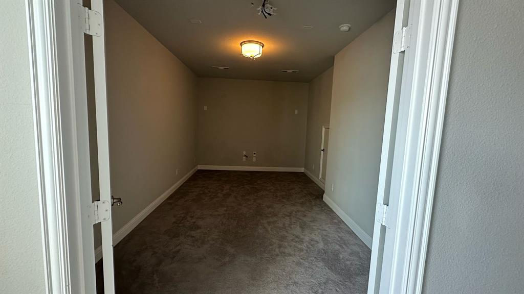 Spacious upper-level room featuring vaulted ceilings, ceiling fan with integrated lighting, expansive triple-window configuration with plantation shutters, neutral carpet flooring, and generous square footage ideal for multiple uses