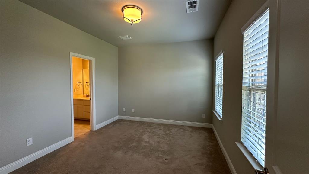 Carpeted room with neutral wall tones and a single window with blinds