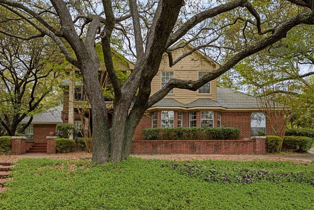 Brick exterior with bay windows and a shingle roof