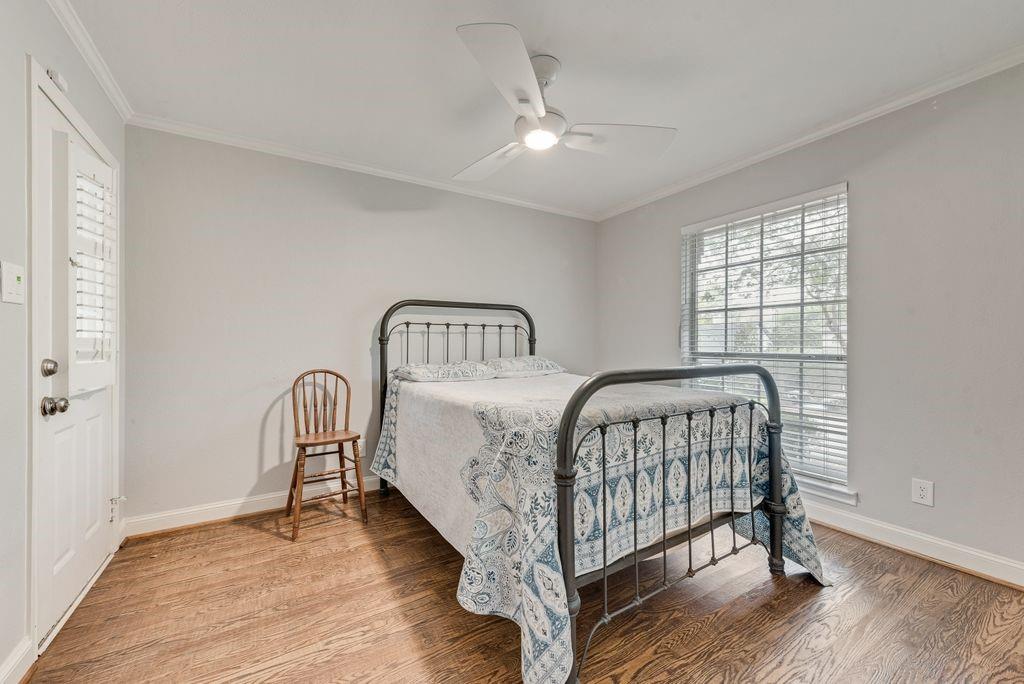 Wood-finish flooring, white ceiling fan, white window blinds, painted walls, and white trim