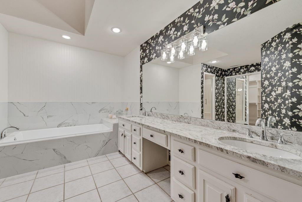 Dual vanity with stone-finish countertops, undermount sinks, and chrome fixtures