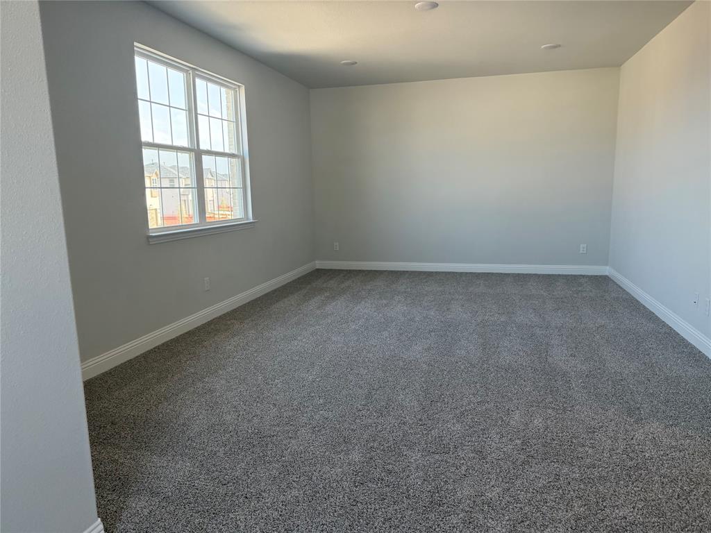 Recessed ceiling lighting, neutral gray wall paint, white trim, and gray carpet