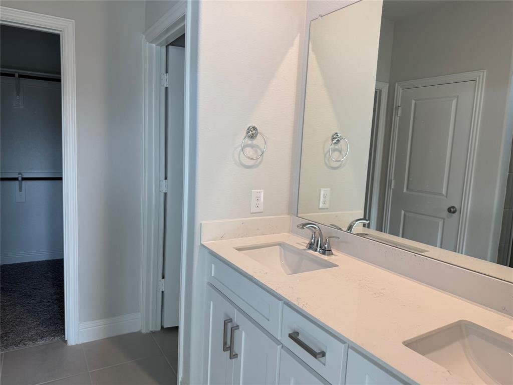Dual vanity with undermount sinks, stone countertop, and chrome fixtures