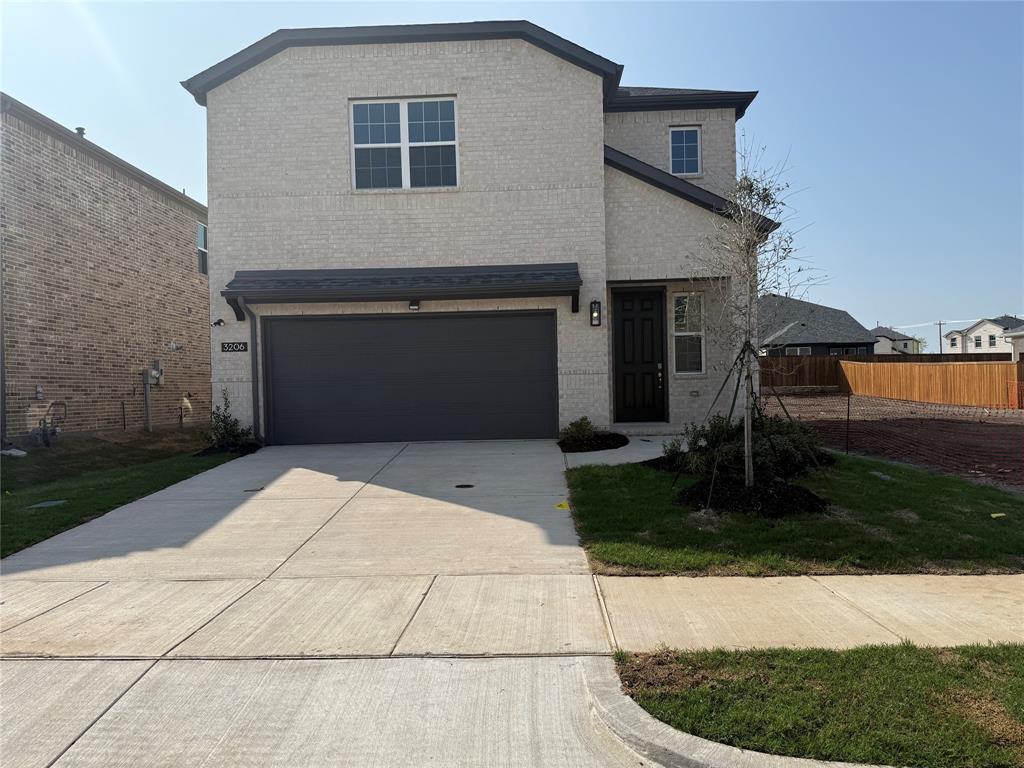 Two-story exterior featuring brick cladding and a dark gray garage door Two-story exterior featuring brick cladding and a dark gray garage door