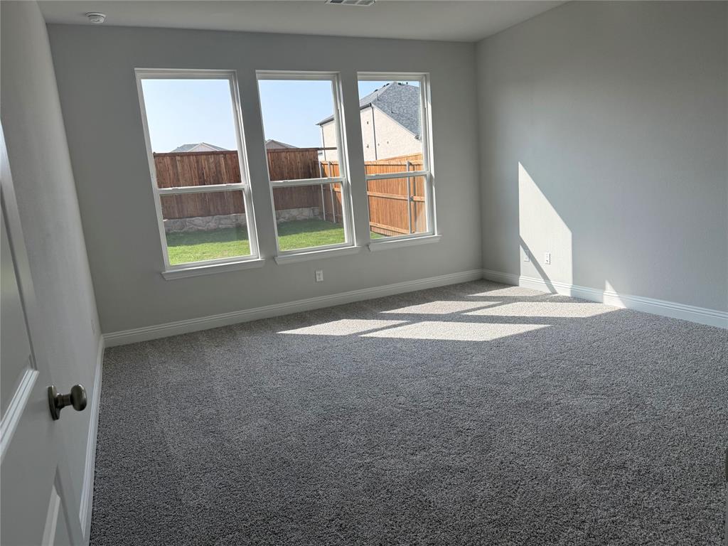 Three large windows, fresh gray carpeting, and neutral wall tones