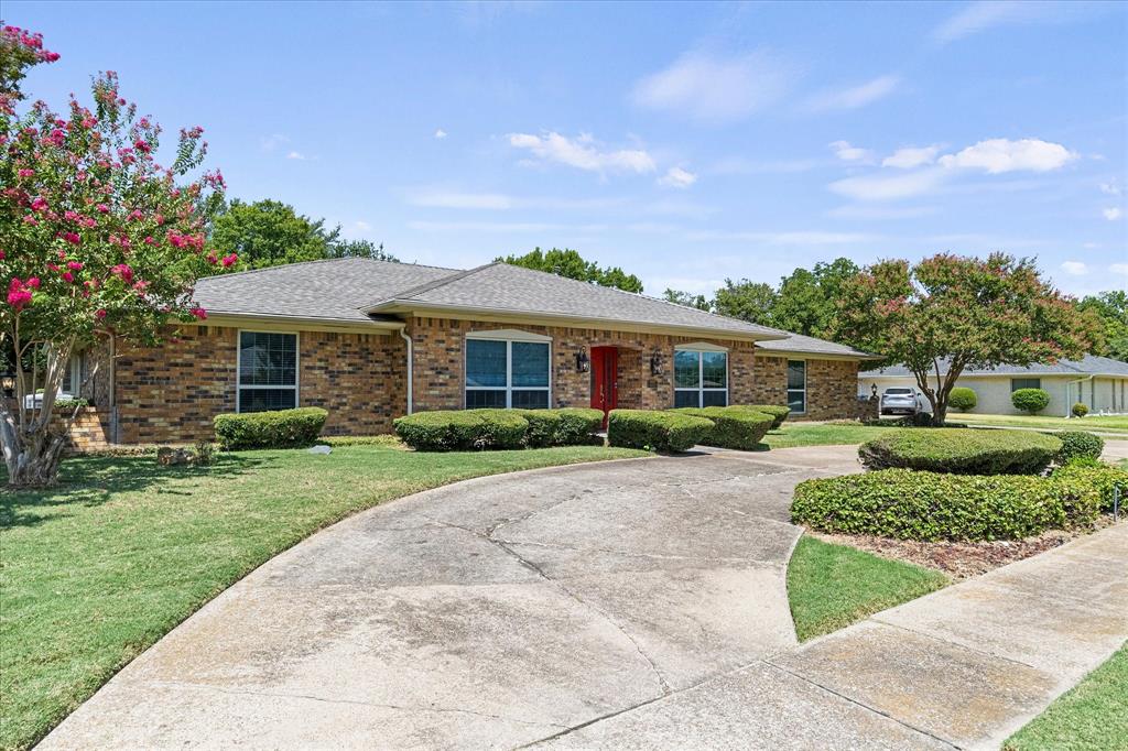 Drive up to this lovely ranch-style home featuring beautiful curb appeal, a welcoming circular driveway, and meticulously maintained landscaping.