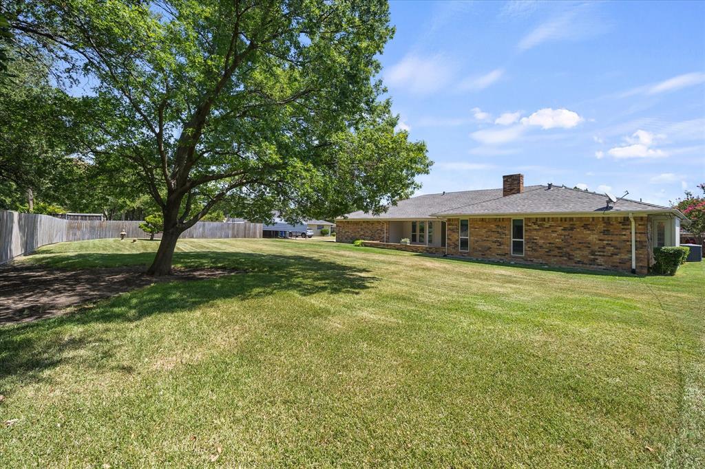 Expansive backyard with mature shade tree and plenty of room for outdoor entertaining, play, or relaxation.