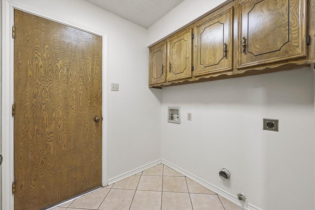 Laundry room with overhead cabinetry.  Door leads to garage.