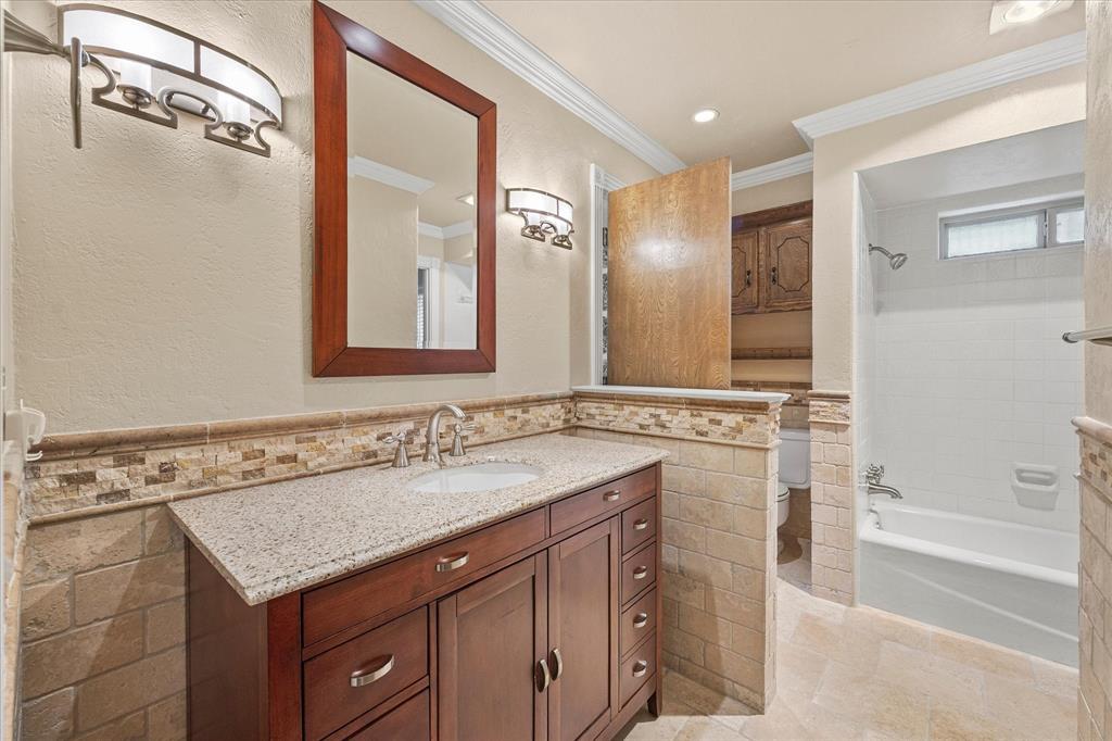 Full bath, decorative tile, neutral colors and lovely cabinetry.