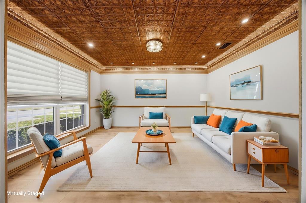 Virtually staged living area showcasing a stunning decorative tin ceiling, rich architectural details, accent lighting, and abundant natural light.  This room could also be an amazing office-study with the rich color tones, accented with the Hunter Douglas Vignette Window Shades with the Lite Rise, Top down, bottom-up shades.