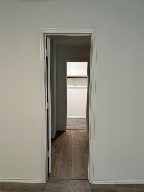Corridor with wood finished floors and baseboards