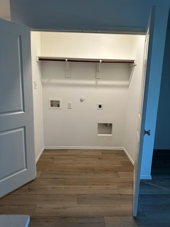 Laundry area featuring electric dryer hookup, hookup for a gas dryer, wood finished floors, and washer hookup
