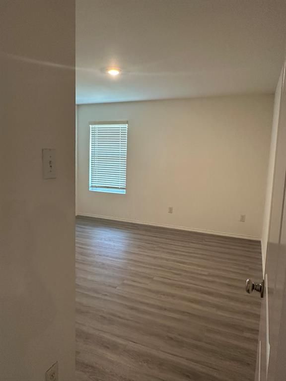 Empty room featuring wood finished floors and baseboards