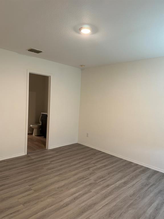 Spare room featuring wood finished floors and a textured ceiling