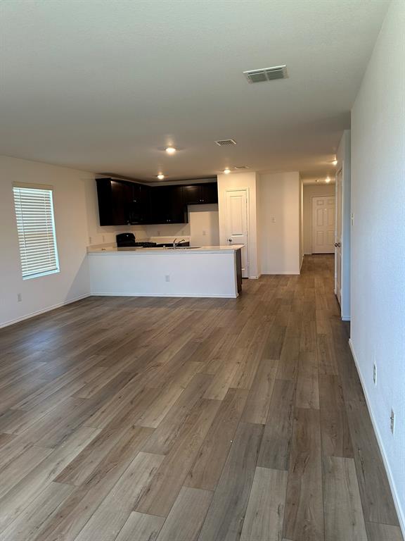 Unfurnished living room featuring wood finished floors and recessed lighting Unfurnished living room featuring wood finished floors and recessed lighting