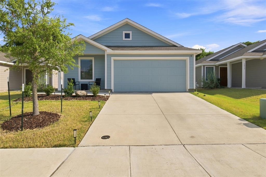 Single-story residence featuring light blue siding, an attached two-car garage, and a concrete driveway