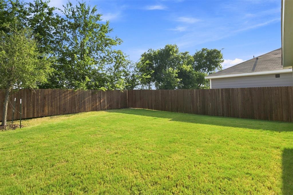 Expansive green lawn with a wood privacy fence