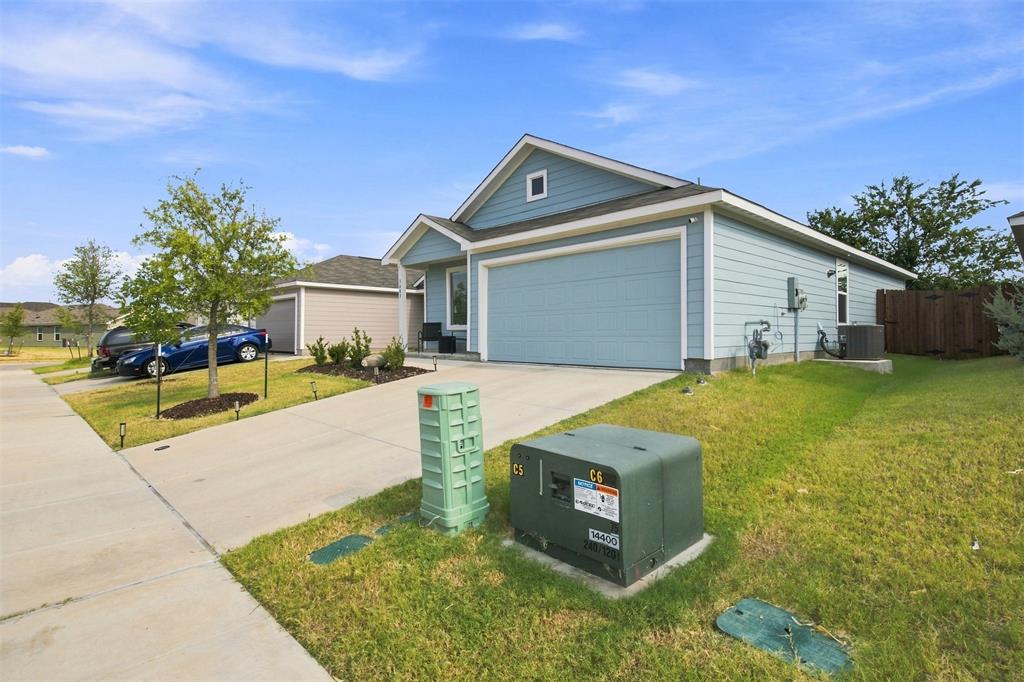 Light blue siding with white trim, two-car garage, concrete driveway, and a manicured lawn