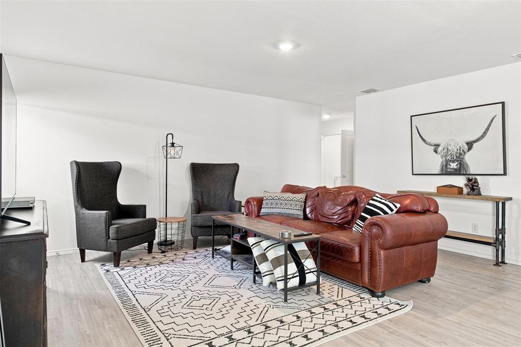 Light wood-finish flooring, recessed lighting, and a console table with industrial-style legs