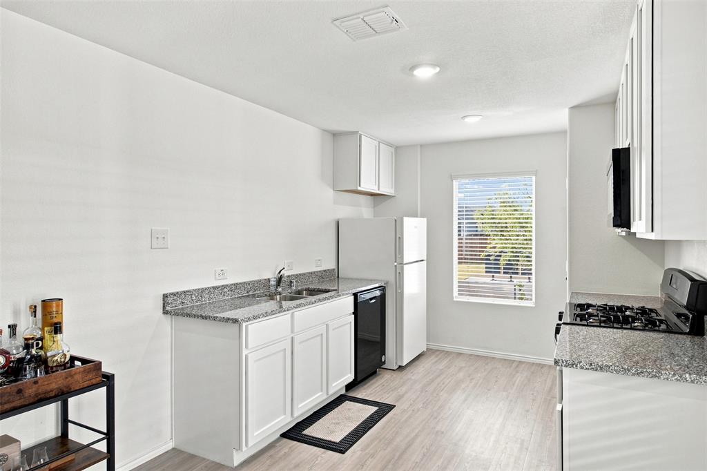 Kitchen featuring white cabinetry, granite-style countertops, wood-finish flooring, and recessed lighting