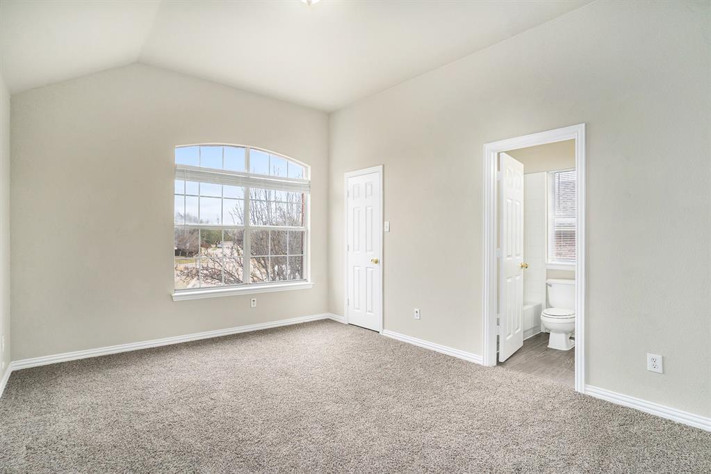 Unfurnished bedroom with carpet, lofted ceiling, and ensuite bathroom