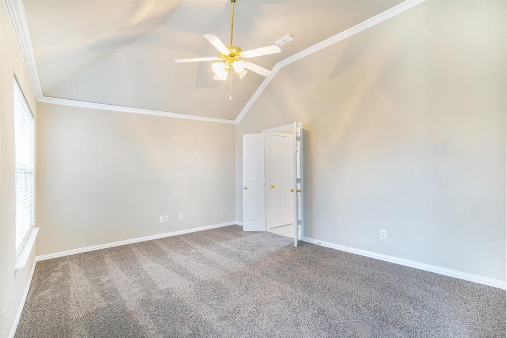 Unfurnished room with lofted ceiling, ceiling fan, carpet floors, and crown molding