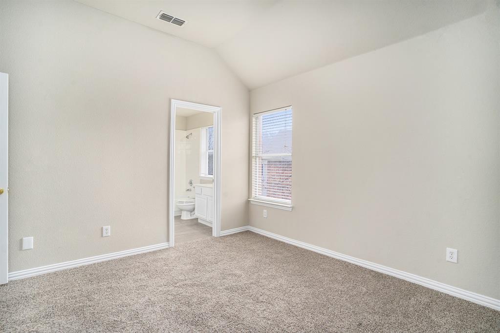 Empty room with carpet floors and lofted ceiling